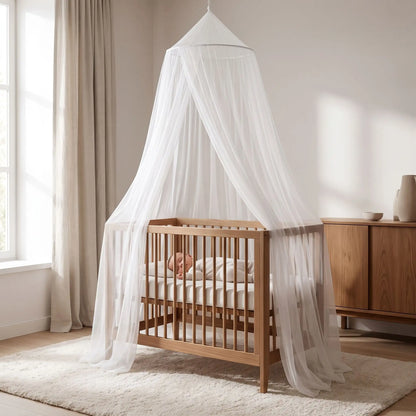 un ciel de lit blanc au dessus du berceau avec un bébé qui dort