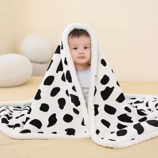 une couette bébé avec des tache noir et blanche qui est réconfortante pour le bébé